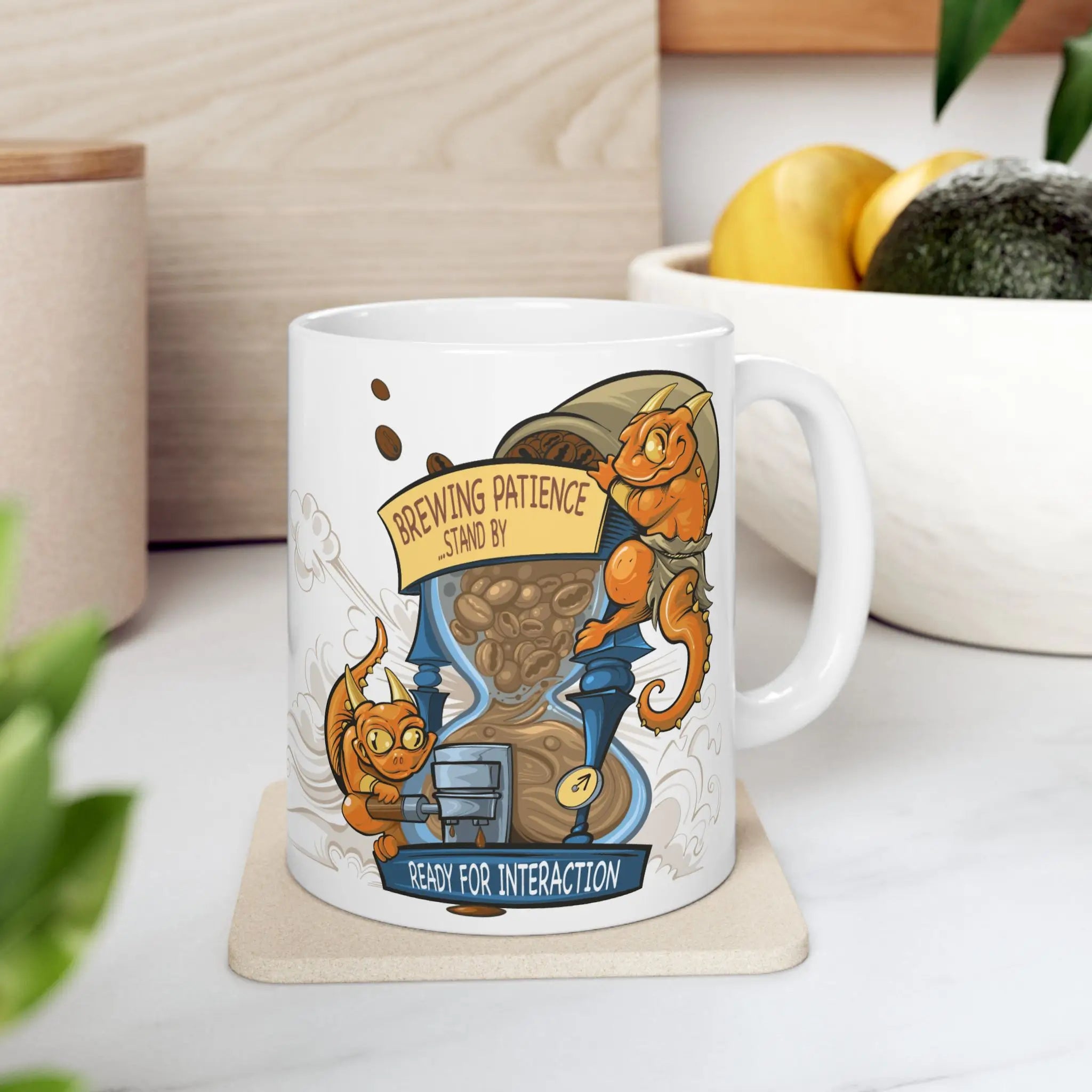 White mug with cartoon design of a cat brewing coffee, placed on a coaster with a wooden background.