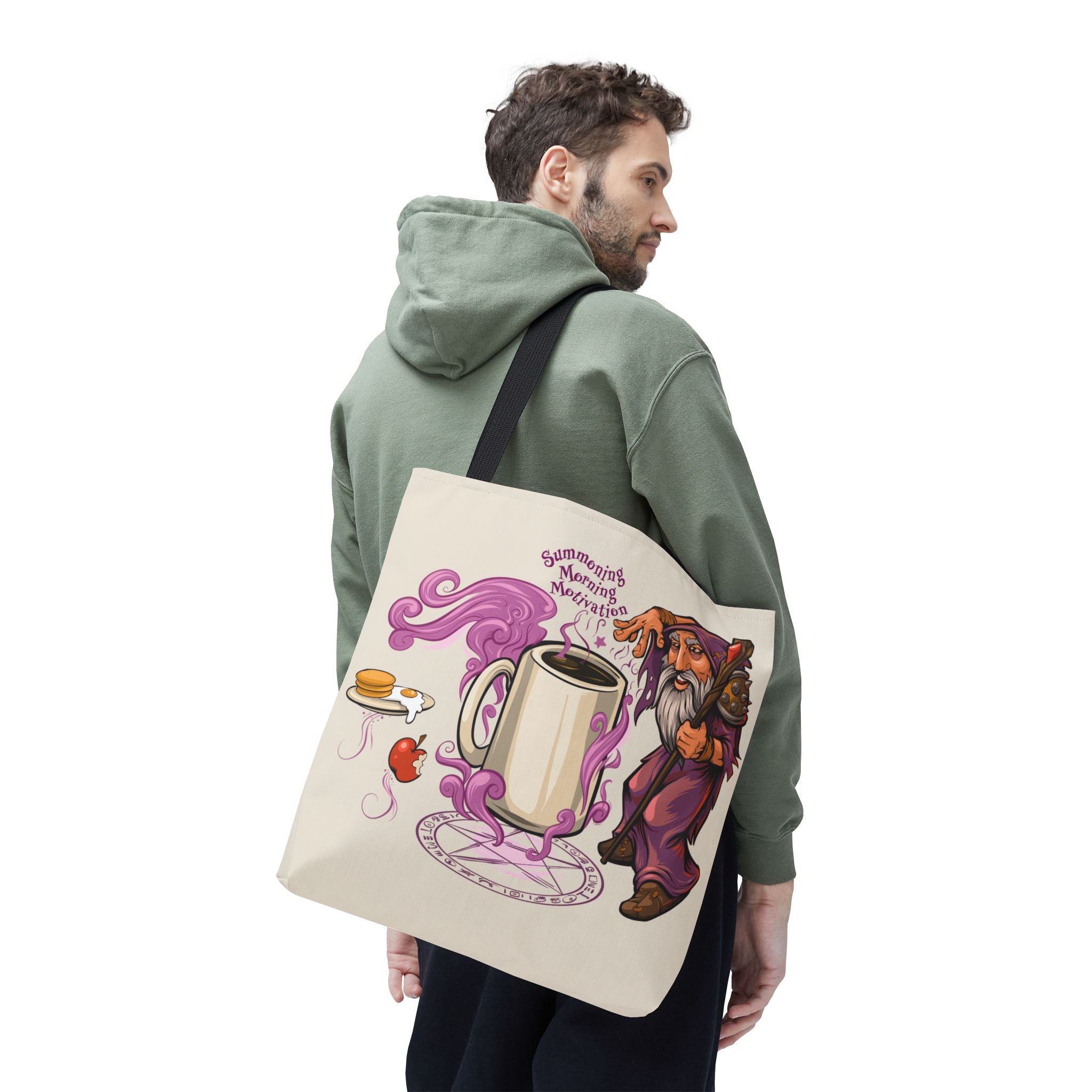 Person wearing a green hoodie carrying a tote bag with a cartoon design of a mug and a wizard.