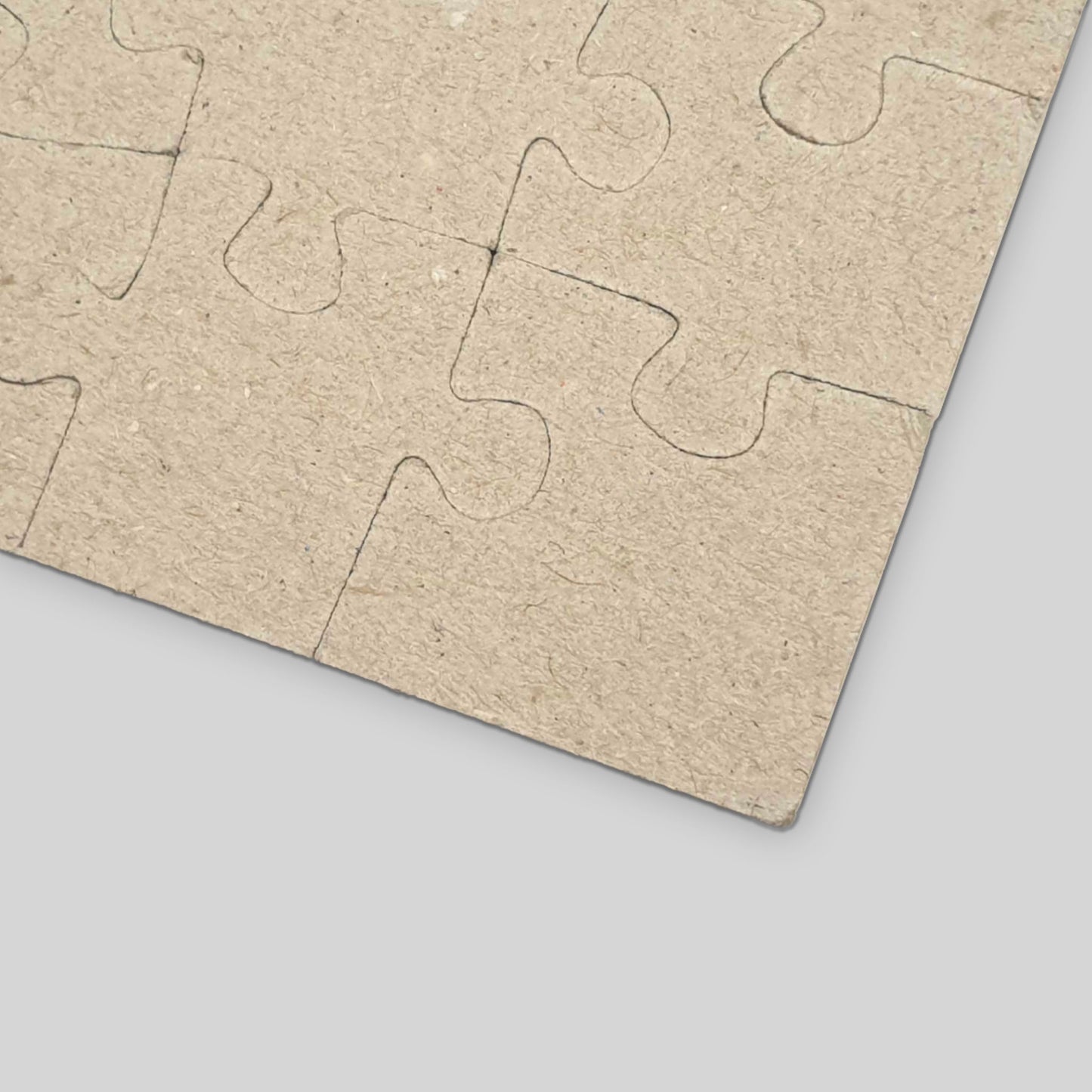 Cardboard puzzle pieces on a gray surface
