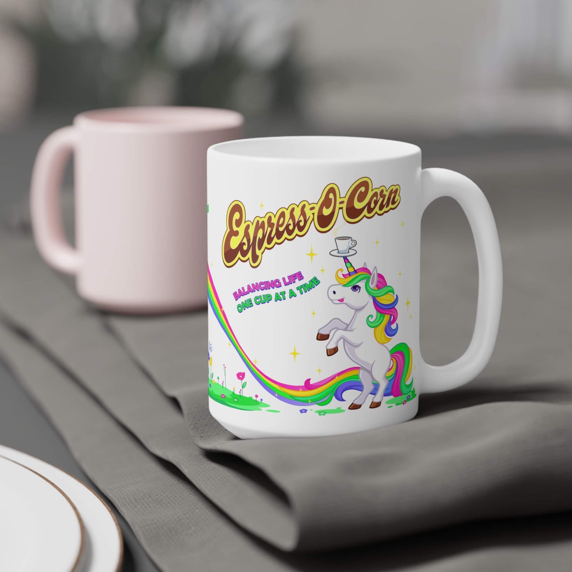 White mug with a colorful unicorn design and 'Espress-O-Corn' text on a gray surface.
