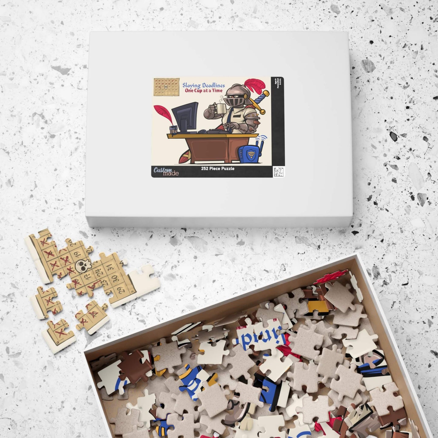 Puzzle set with a box of completed puzzle pieces and a box of unpuzzled pieces on a speckled surface.