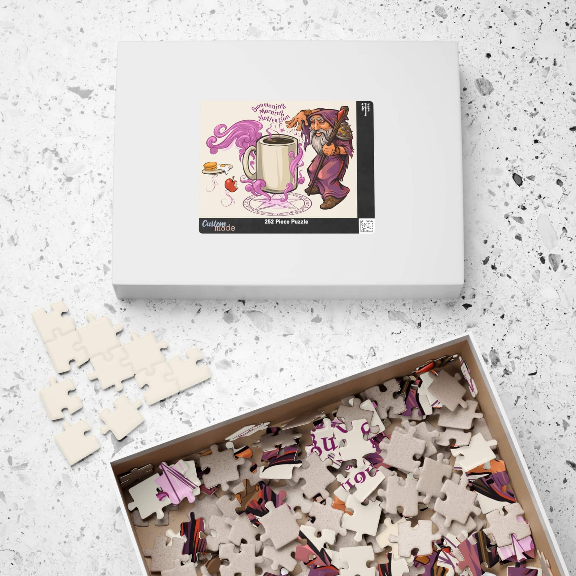 Puzzle set with a box featuring a cartoon bear and coffee cup on a speckled surface.
