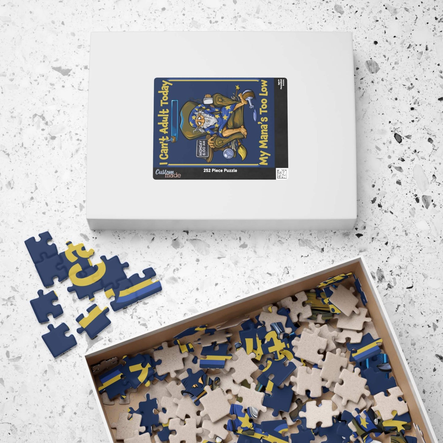 Jigsaw puzzle with pieces scattered and a box on a textured surface