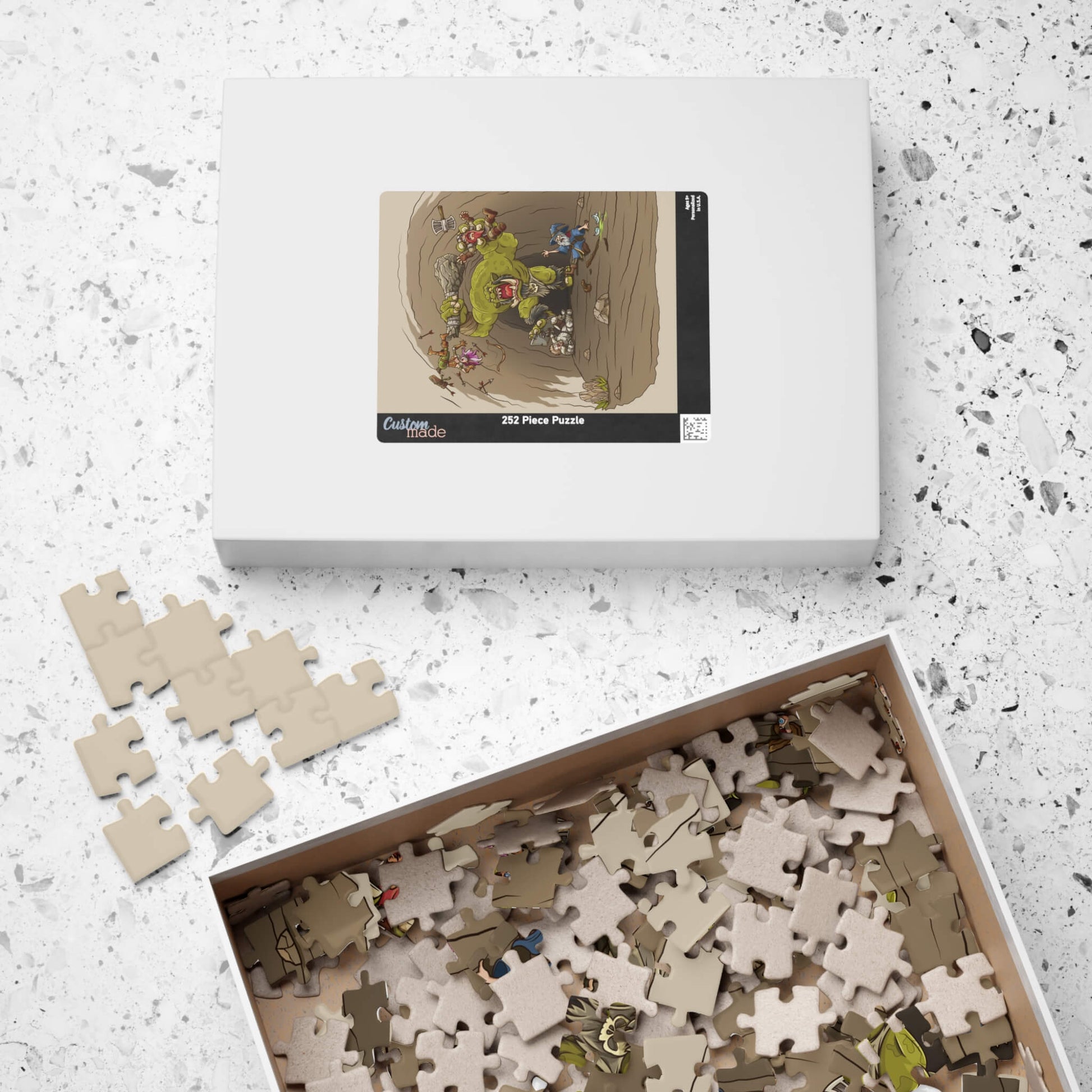 Jigsaw puzzle set with pieces and packaging on a speckled surface