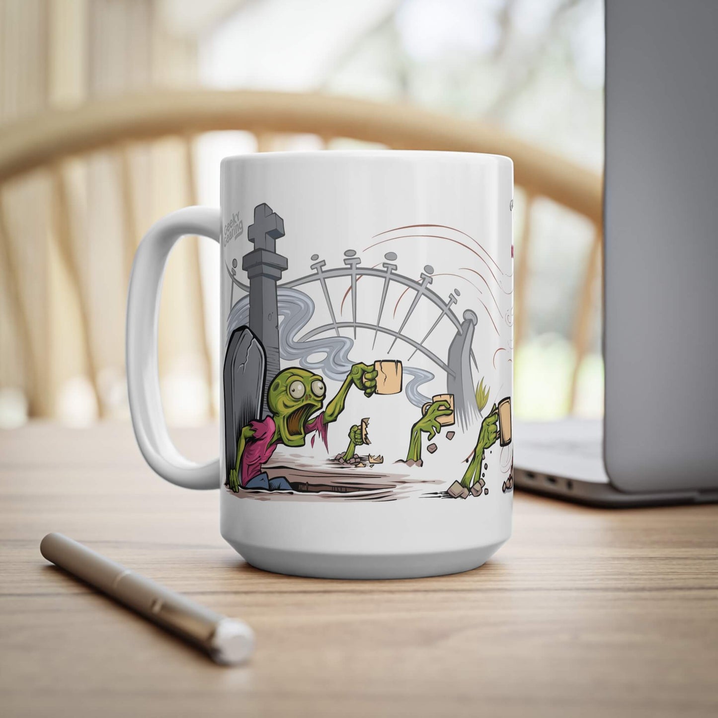 Mug with cartoon design of zombie rising from their grave by a gate on a wooden table.