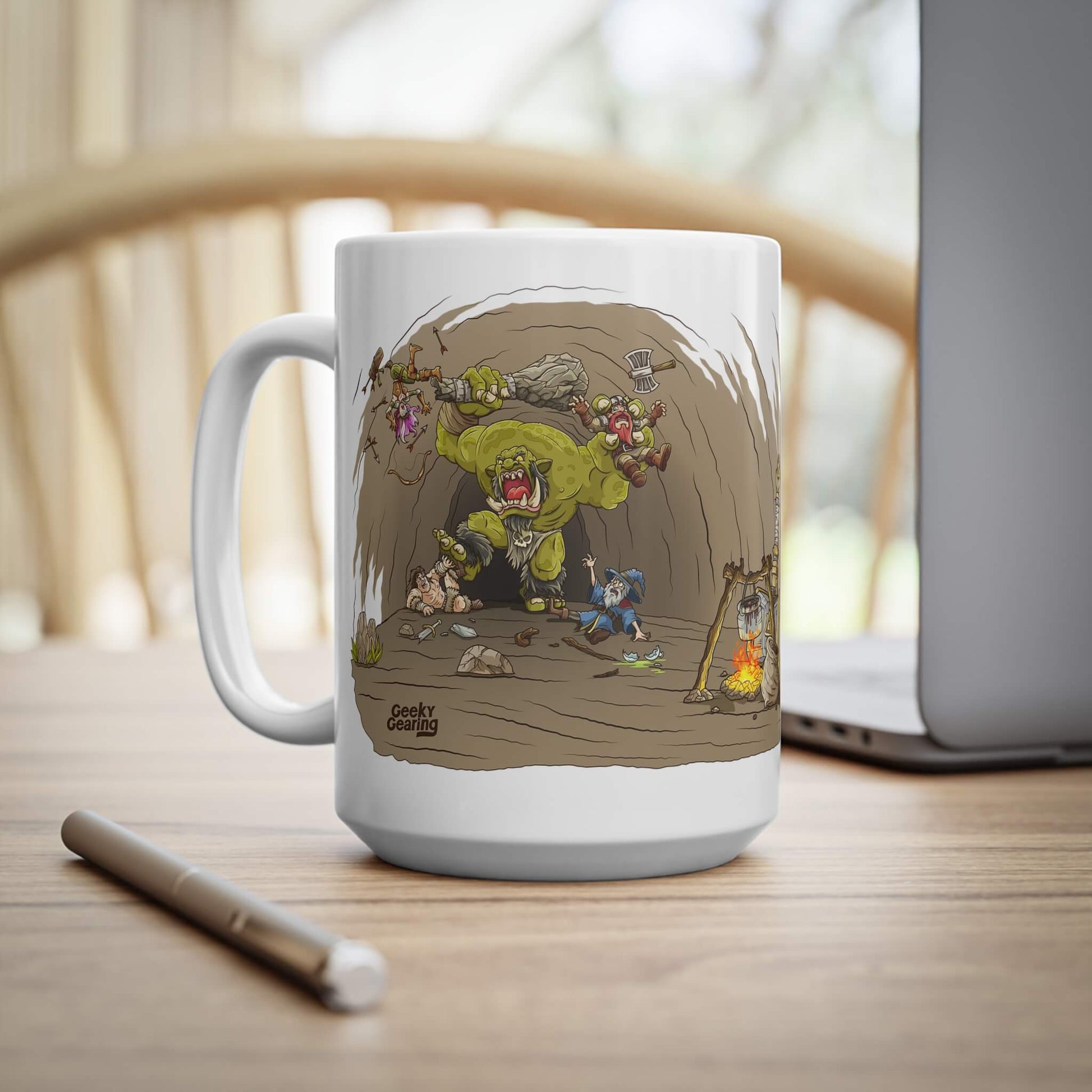 Mug with cartoon design of a battle scene of heroes fighting a monster, on a wooden table