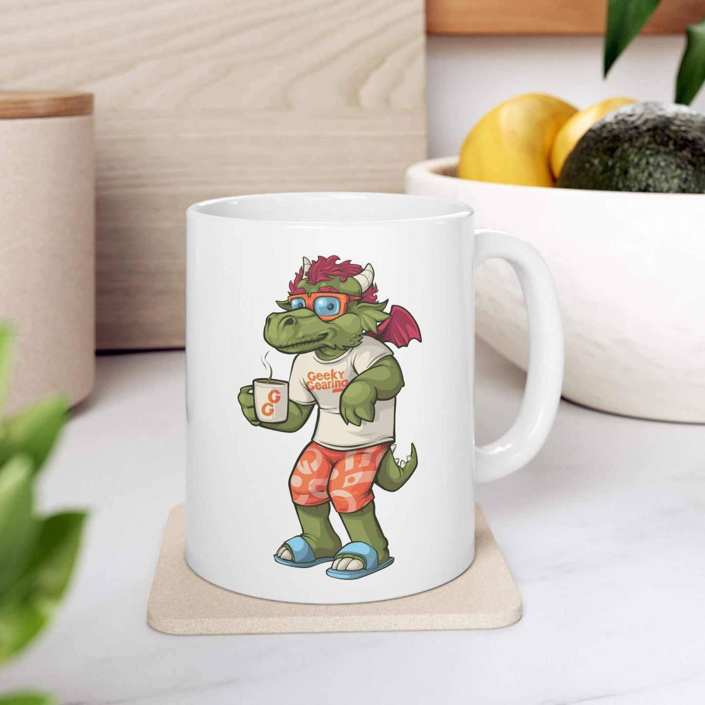 White mug with a cartoon dragon design holding a coffee cup, placed on a wooden coaster.