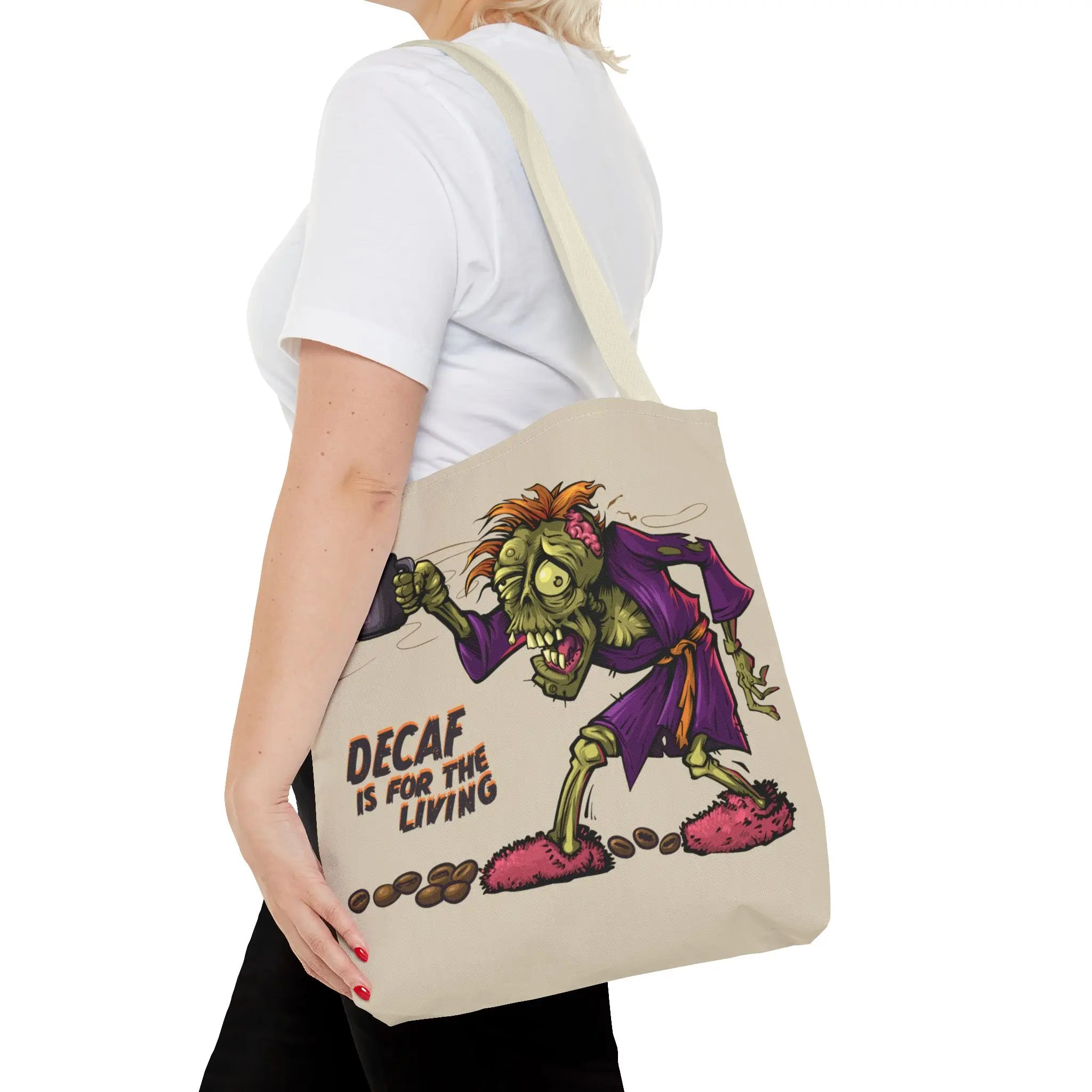 Person holding a tote bag with a cartoon zombie design and text on a white background