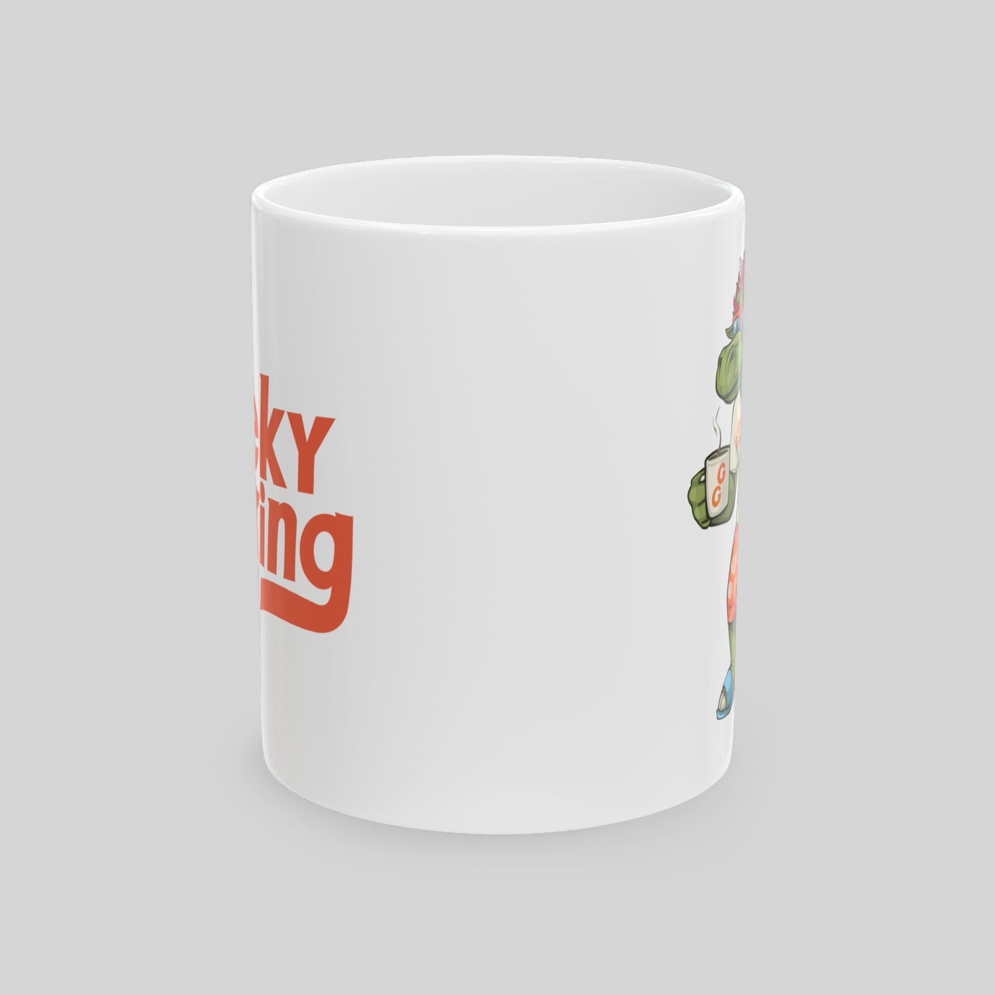 White mug with red text and green graphics on a gray background