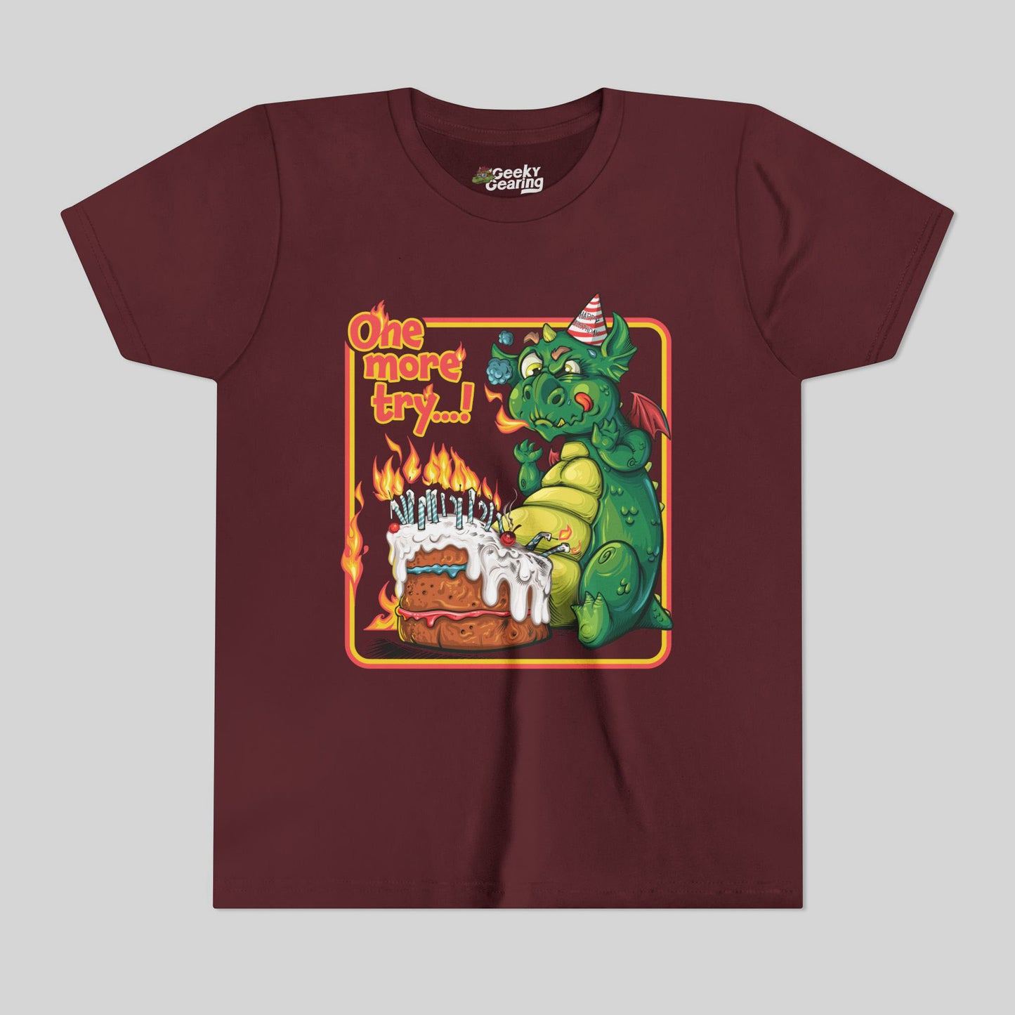 Maroon t-shirt with a dragon and birthday cake graphic on a gray background