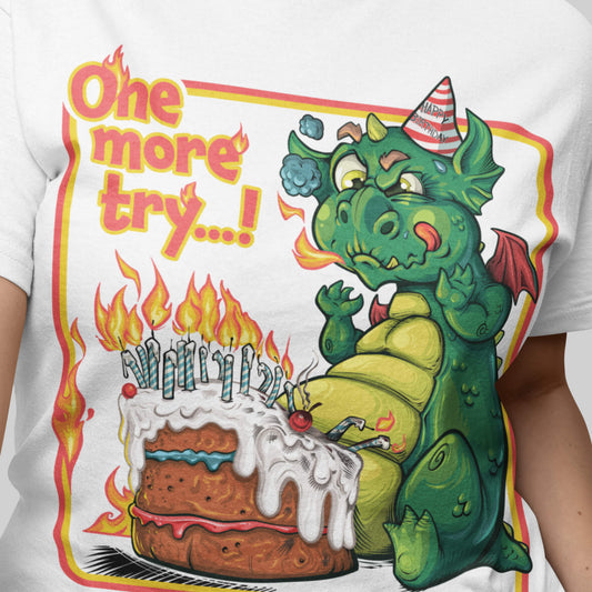 T-shirt with a green dragon and birthday cake graphic and text 'One more try...!'.