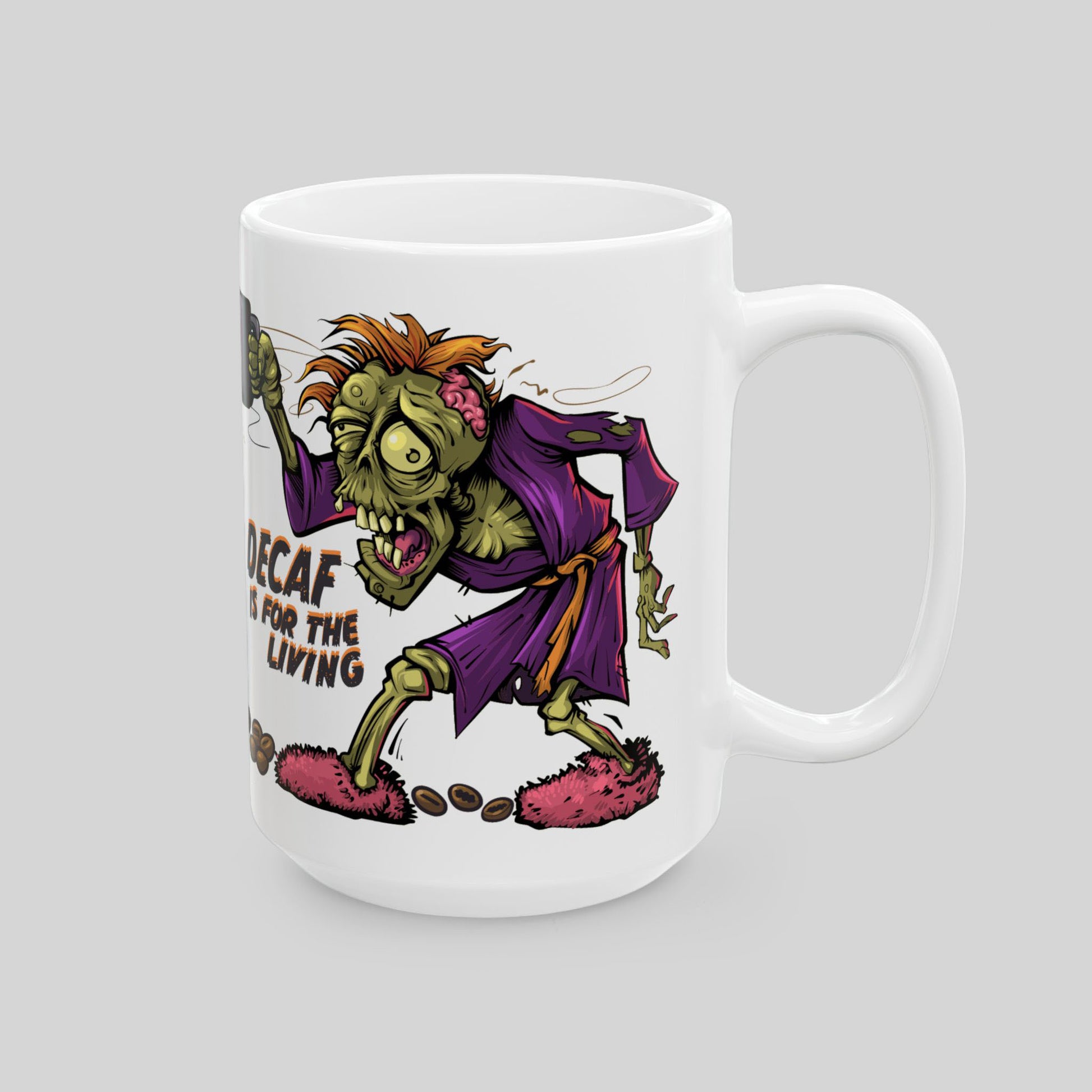 White 15 oz ceramic mug with cartoon zombie holding coffee; text: “Decaf is for the Living”