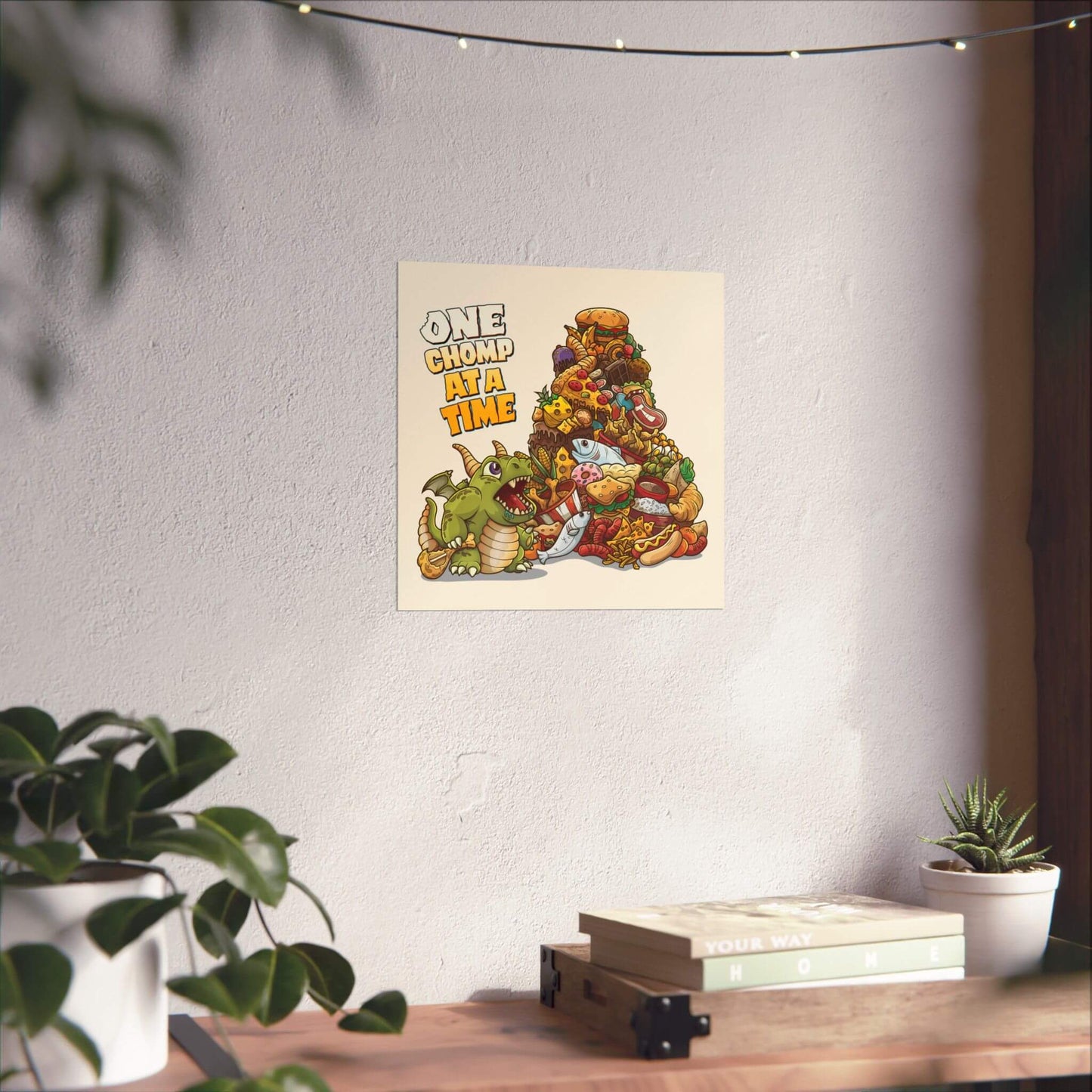 Funny baby dragon poster shown on a wall: a tiny dragon eyeing a mountain of junk food, 'One Chomp at a Time'.