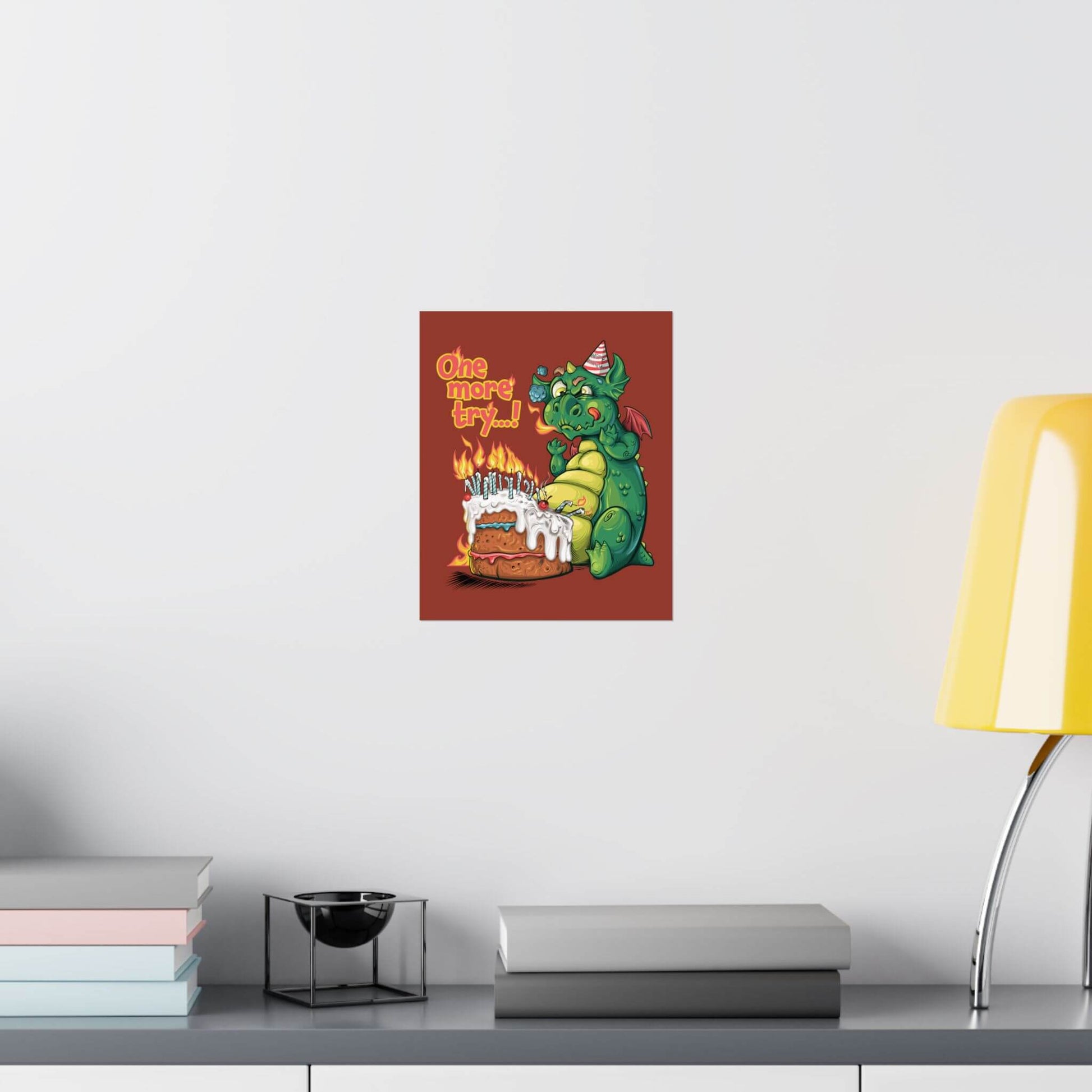 Funny dragon birthday poster shown on a wall: too winded to blow out a cake's flaming candles, 'One More Try...!'.