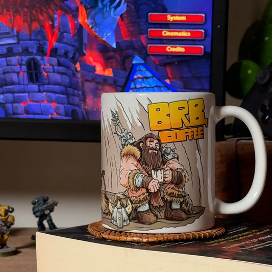 Video of GeekyGearing Barbarian’s Coffee Break mug rotating on coaster atop book; blurred minis behind; coffee poured from moka pot.